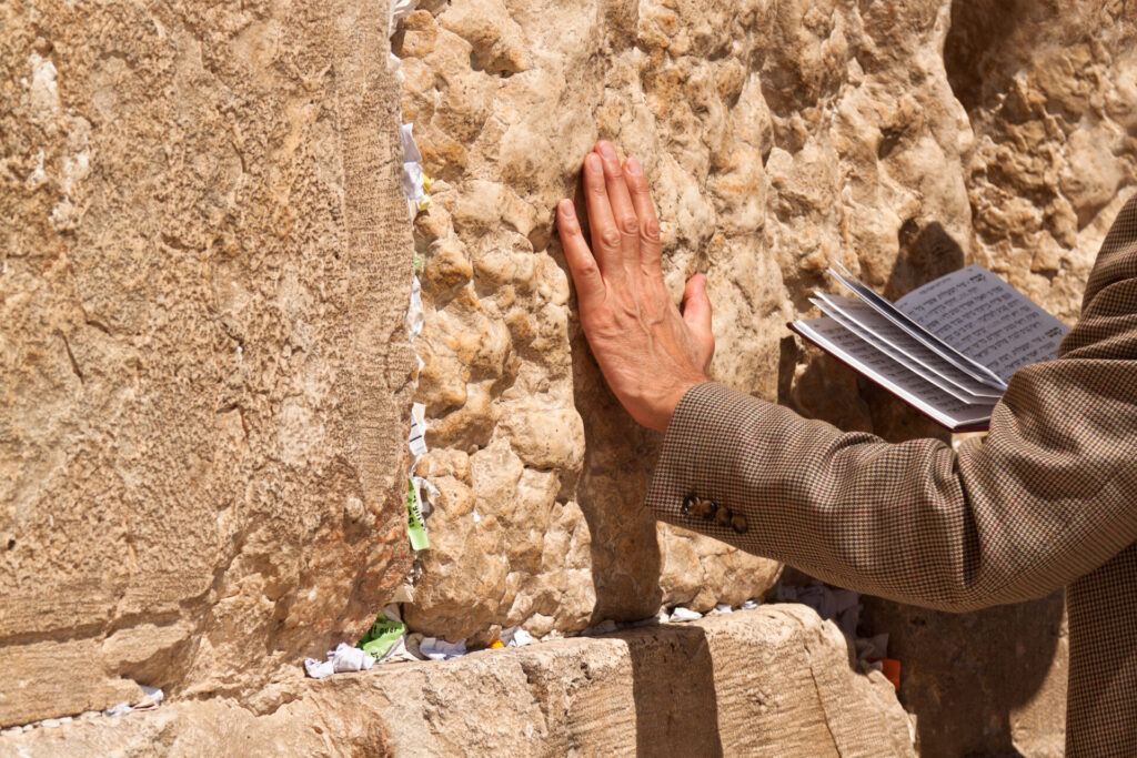 Sharm el Sheikh do Jerozolimy -Modlący się z książką w ręku, opierający się o Ścianę Płaczu